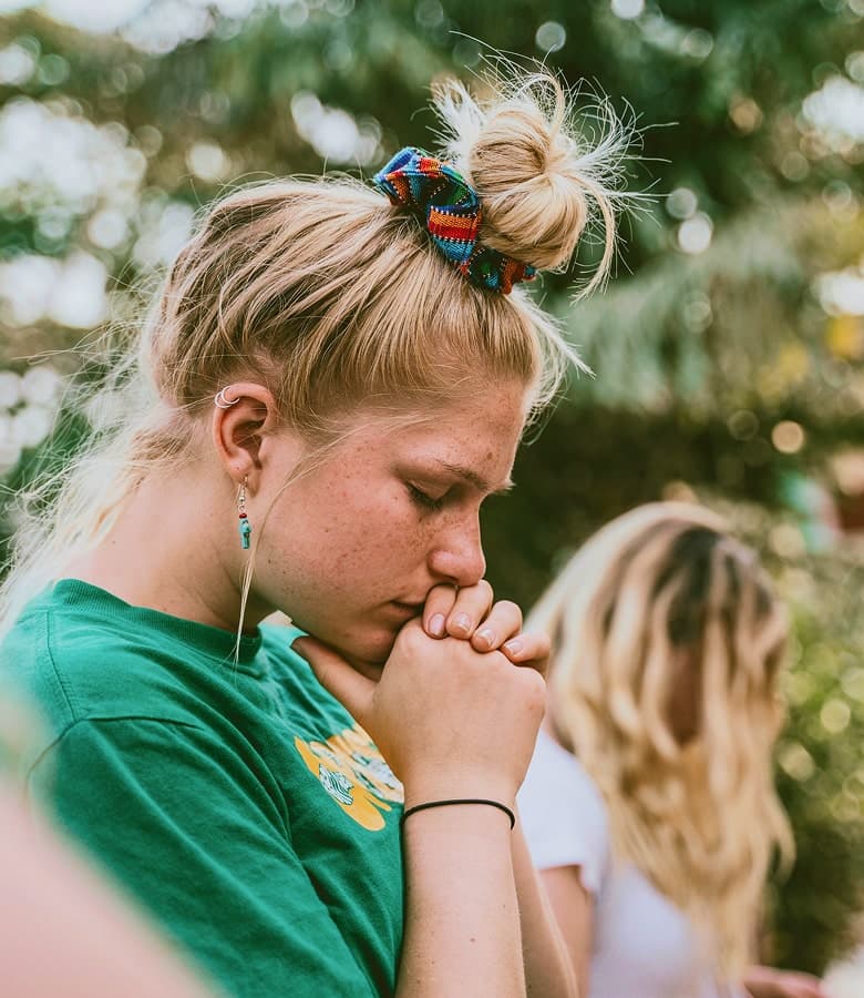 Young woman praying at RENEW Church